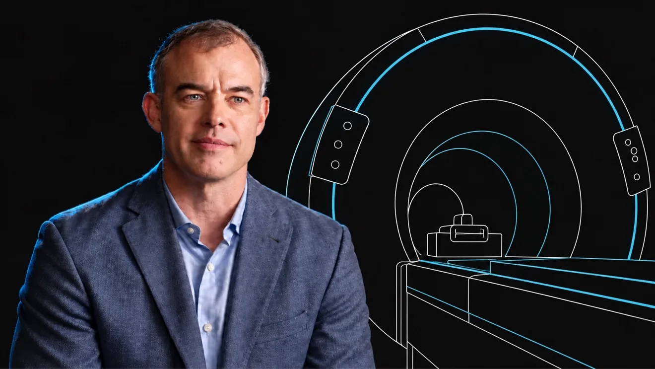 Synaptive interview speaker with blue accent lighting beside a white and cyan line drawing of the MRI scanner